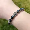Bratara din piatra de Hematit cu mana Fatimei, talisman cu rol de protectie, elastica, 9 cm negru
